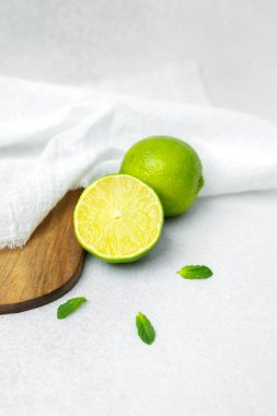 Sulu limon ve nane yaprakları sade ahşap bir tahtanın üzerine dizilmiş..