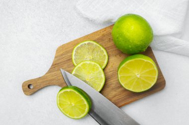 Bir şef ustalıkla taze limonları parlak bir mutfakta ahşap bir tahtada dilimler..
