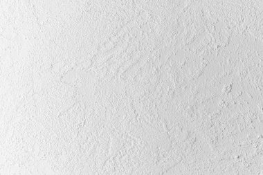 Yumuşak ve pürüzlü bir yüzeyi olan desenli beyaz bir duvarın yakın görüntüsü.