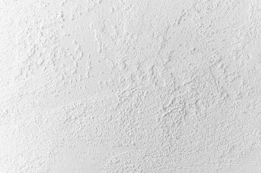 İlginç doku ve desenlere sahip beyaz bir duvarın yakın görüntüsü.