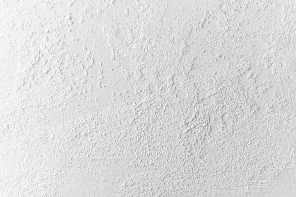 İlginç doku ve desenlere sahip beyaz bir duvarın yakın görüntüsü.
