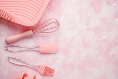 Pembe fırınlama araçları ve yumuşak pembe duvar arka planında çırpma