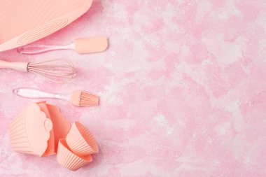 Kapkek silikon kalıpları ve pembe fırın kapları pembe duvar arka planında