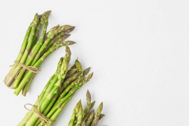 Beyaz desenli arka planda taze yeşil kuşkonmaz demetleri