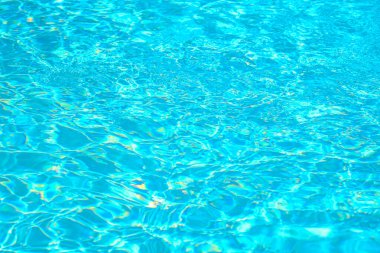 Güneş ışığı altında parlayan canlı turkuaz havuz suyu yüzeyi