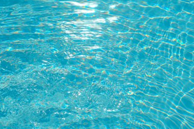 Kristal berrak havuz su yüzeyi ışık desenleri ve yansımaları ile