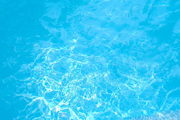 Kristal berrak havuz su yüzeyi ışık desenleri ve yansımaları ile