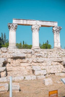 Yunanistan 'da açık mavi gökyüzü altında korunmuş doric sütunları bulunan Antik Korint kalıntıları