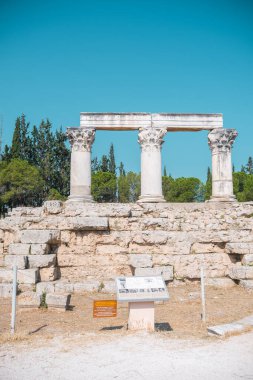 Yunanistan 'da açık mavi gökyüzü altında korunmuş doric sütunları bulunan Antik Korint kalıntıları