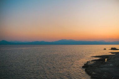 Yunanistan 'da gün batımında palmiye ağaçlı Rocky sahili