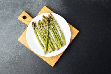 Taze ızgara kuşkonmaz ahşap bir tabağa konur, eğlenmeye hazır..