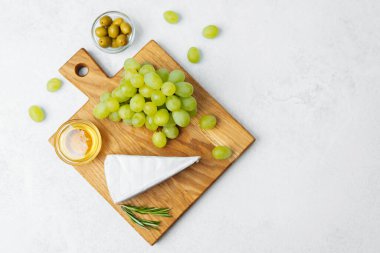 Tahtada peynir, yeşil üzüm, zeytin ve bal sergileniyor..