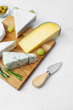 Peynir, peynir, gouda ve mavi üzümler ve otlarla servis edilir..