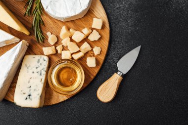 Peynir ve bal seçimi tahta bir tahtada bıçakla düzenlenir..