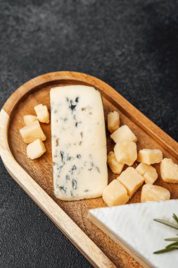 Tahta bir tahtanın üzerinde küp şeklinde aromalı peynirler sergileniyor..