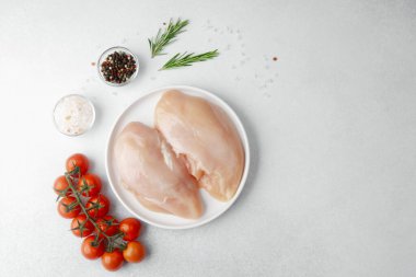 Tuz, biber, biberiye ve kiraz domatesli çiğ tavuk göğsü.