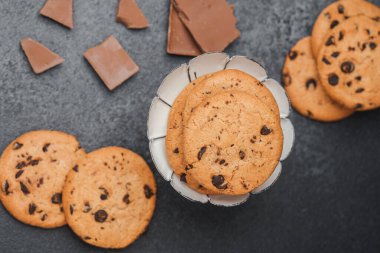Bir tabak taze çikolatalı kurabiye ve çikolata parçaları..