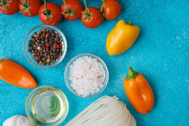 çeşitli yemek malzemeleri erişte ve sebzeli mavi arka planda