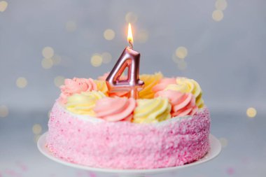 Pembe ve sarı kremalı canlı bir pasta bir çocuğun 4. doğum gününü kutlar..