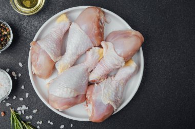 Tavuk budu çiğ, baharatlı ve otlu beyaz tabakta.