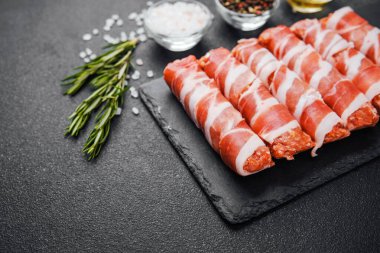 Jambona sarılmış sosis siyah tahta ve baharatlı.