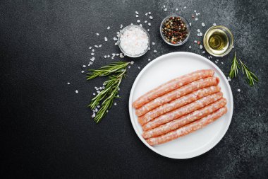 Beyaz tabakta taze domuz sosisi ve baharat.