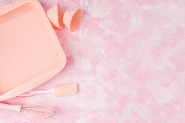 Kapkek silikon kalıpları ve pembe fırın kapları pembe duvar arka planında