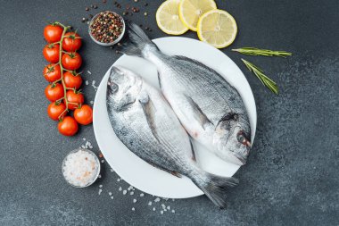 Çiğ dorado balığı, domatesli limon ve baharatlı beyaz tabak.