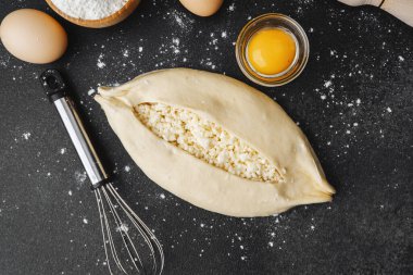 Çiğ khachapuri ile kaplanmış yüzey, yumurta ve fırın için merdane.