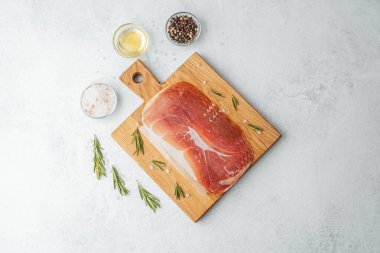 Jambon dilimleri tuz, otlar ve baharatlarla dilimlenmiş.