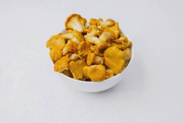 Altın mantarlarla dolu bir kase açık bir yüzeyde duruyor..