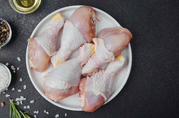 Tavuk budu çiğ, baharatlı ve otlu beyaz tabakta.