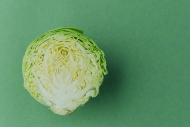 Yarım lahana üst görünümü düz yeşil arkaplan üzerinde yatıyordu