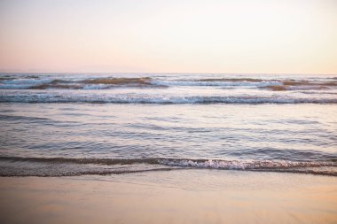 Yumuşak sahil dalgaları Pastel yansımaları ve yumuşak okyanus ışığı