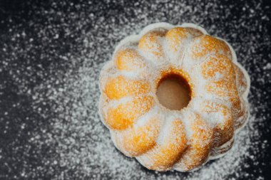 Siyah arkaplanda pudra şekerli kek 