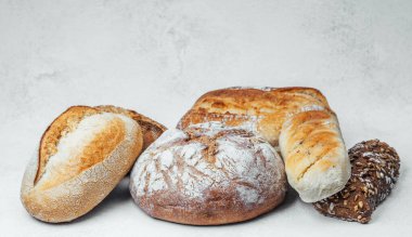 Basit bir arka planda sanatsal olarak sıralanmış taze ekmek somunları..