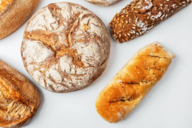 Yuvarlak ve uzun şekilleri de içeren taze pişmiş ekmekler çeşitli dokular sergiliyor..