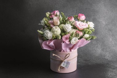 Zarif bir kapta pembe ve beyaz çiçeklerle sersemletici bir çiçek sergisi..