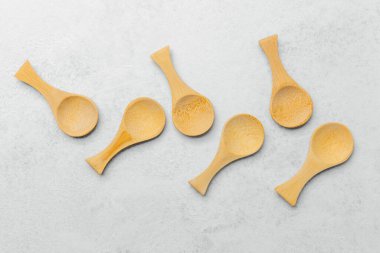 Tarafsız bir yüzeyde altı tahta kaşık zarif bir şekilde sergilenir..