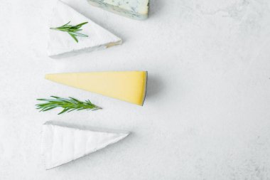 Tarafsız bir yüzeyde biberiye ile sıralanmış farklı peynir türleri.