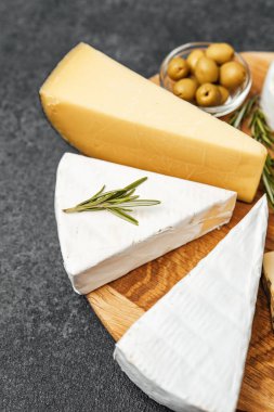 Farklı peynir türleri yeşil zeytinlerin yanında cezbedici bir şekilde düzenlenir..