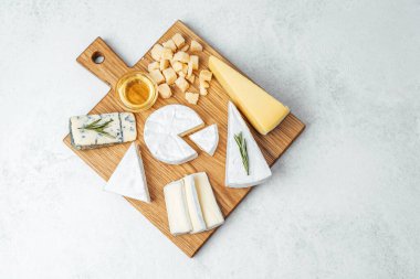 Peynir, bal ve otlar toplanmak için ahşap bir tabakta ustalıkla dizilmiş..