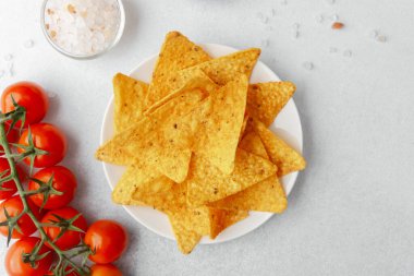 Domatesli çıtır cips, beyaz arka planda salsa ve tuz.