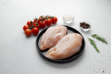 Çiğ tavuk göğsü ve taze domates, tuz, biber ve biberiye.