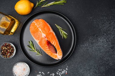 Taze bitkiler, limon dilimleri ve zeytinyağıyla hazırlanmış somon filetosu. Pişirmeye hazır..