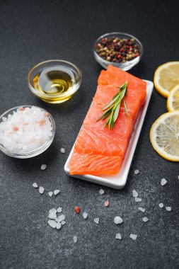 Taze somon filetosu, yakınlarda güzel otlar, baharatlar ve limonlarla sunuluyor..