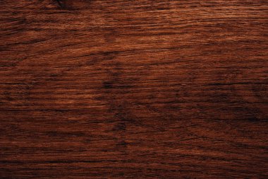 Sıcak kırmızı-kahverengi ahşap yüzey, zengin doku ve ince doğrusal tahıl detaylarıyla.