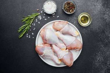 Tavuk budu çiğ, baharatlı ve otlu beyaz tabakta.