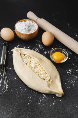 Çiğ khachapuri ile kaplanmış yüzey, yumurta ve fırın için merdane.