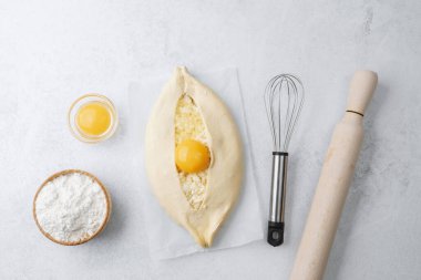 Yumurta sarısı ve beyaz arka planda çırpılmamış khachapuri.